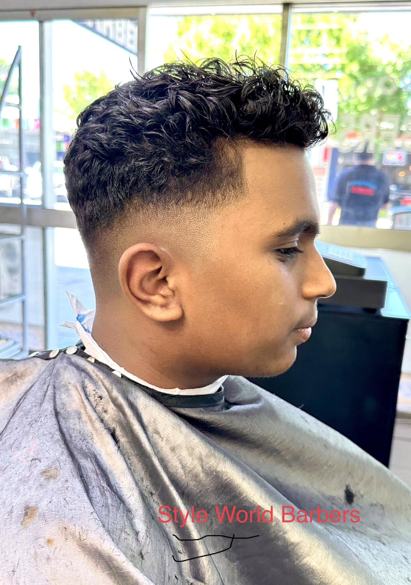 Men's skin fade with curly textured top at Style World Barbers Engadine